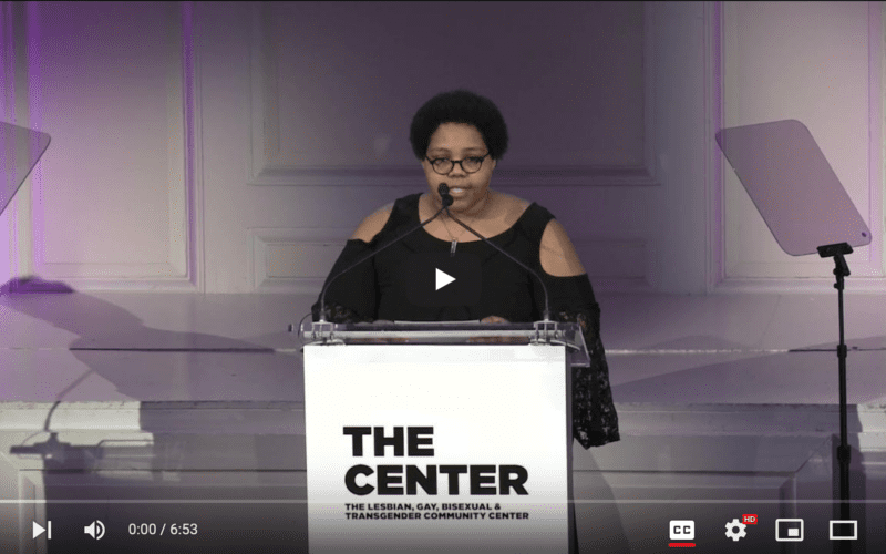 Tatiana B. Martin speaking at the podium of the 2021 Women's Center for the NYC LGBTQ Community Center