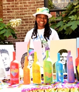 Photo of an artist with colorful bottles in front of them