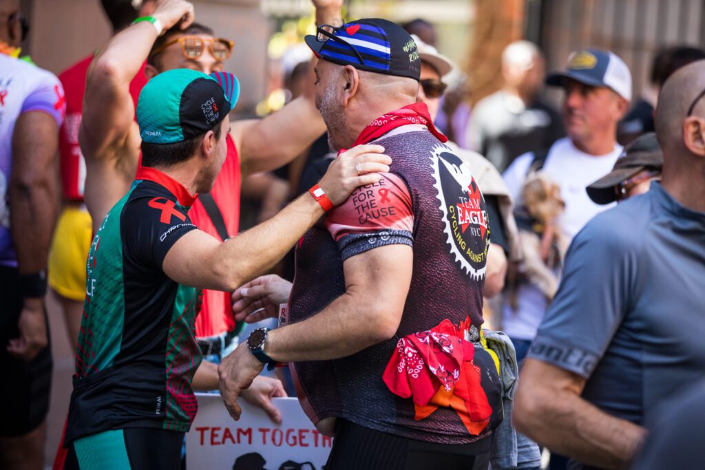 two people talk an look at the crowd. one has his hand on the other's shoulder