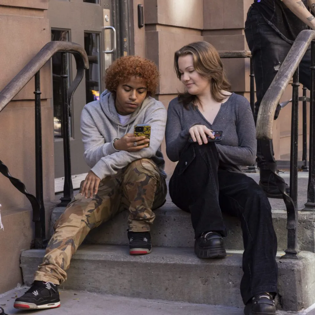 Two people sitting on steps outside of The Center