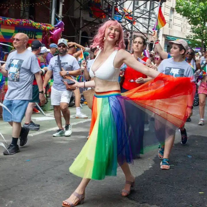 Marcher smiling in Pride parade while walking with The Center