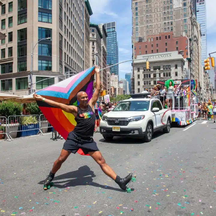 Roller skater holding progress pride flag